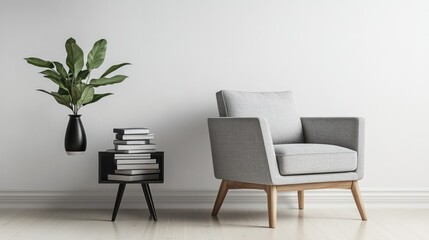 A realistic photo showcasing a stylish gray armchair with wooden legs placed next to a minimalist side table holding books and a black vase with greenery. The clean, neutral tones and sharp lines