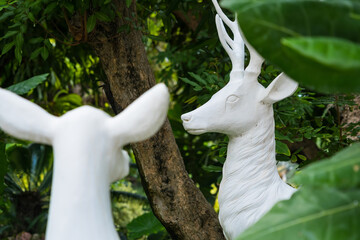 A White Deer Statue in a Lush Green Setting