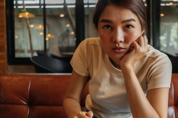 Asian woman working online with computer tablet in a cafe, looking at the camera