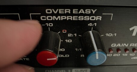 A man adjusts a vocal compressor in a recording studio. Close-up of his hand, an unrecognizable person