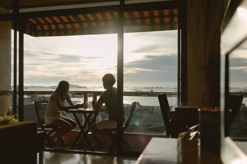 Asian lover couple having dinner enjoy date at private terrace on evening ocean