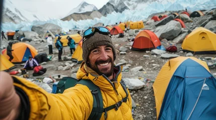 An adventurer cheerfully takes a selfie at Mount Everest base camp, capturing the spirit of exploration amidst colorful tents and breathtaking scenery