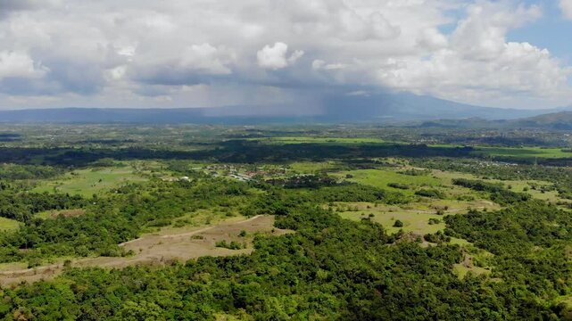 Aerial video of a stretch of green forest with a background of thick raining clouds in the Seulawah mountains, Aceh Besar, Sumatra