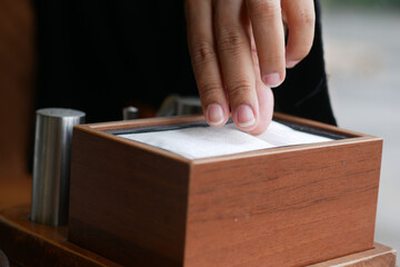  hand pull out a piece of tissue from tissue paper box 