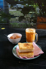 Kaya toast butter with teh tarik and half boiled eggs. Popular in Malaysia and Singapore.