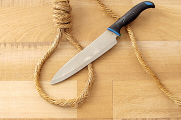 Top View of Rope Noose With Knife on Wooden Background