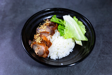 Barbecued pork rice in black bowl