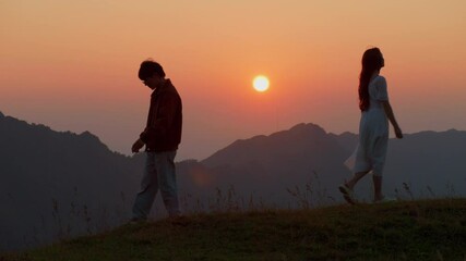 breakup split divorce concept couple departing split broke up walking in opposite direction of mountain path back to back silhouette at sunset