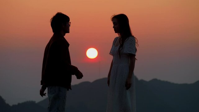 couple silhouette while fighting and breakup relationship at sunrise in mountains hill , divorce separation concept
