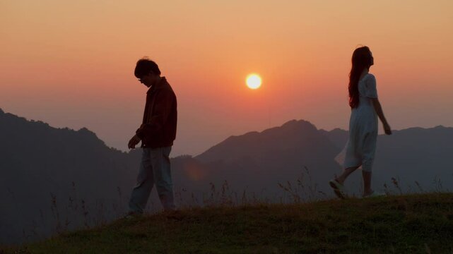 breakup split divorce concept couple departing split broke up walking in opposite direction of mountain path back to back silhouette at sunset