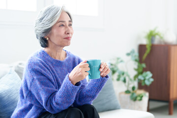 リビングでテレビを鑑賞するグレイヘアの女性