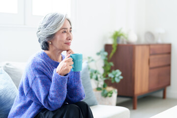 リビングでテレビを鑑賞するグレイヘアの女性