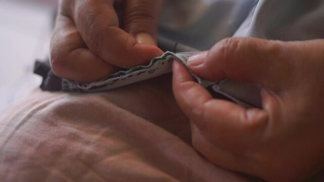 The process of sewing cloth by hand