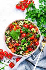 Quinoa vegan salad with avocado, tomatoes, onion and parsley, white background, top view