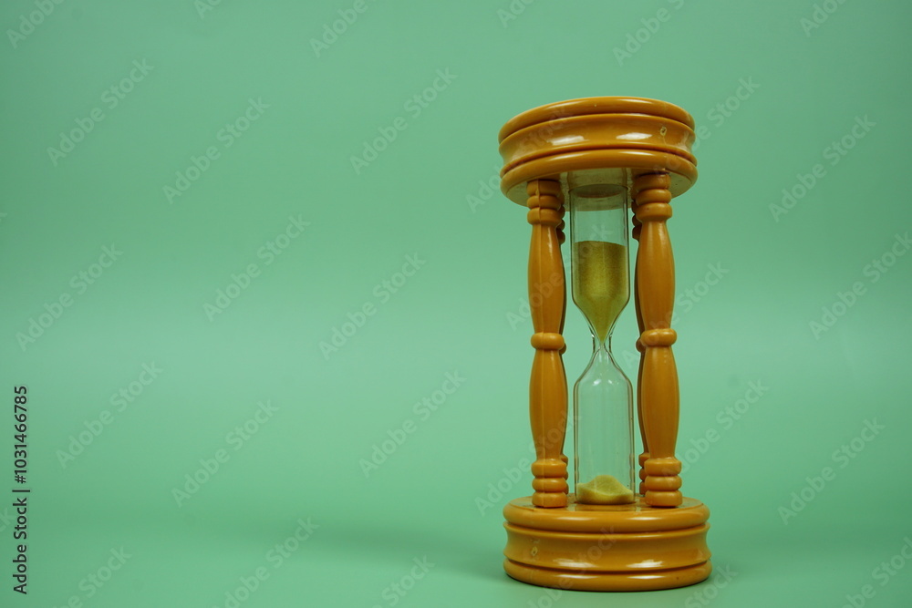 Wall mural hourglass with space for text on green background