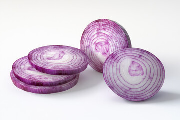 Sliced red onion on white background, arranged in a neat pattern.