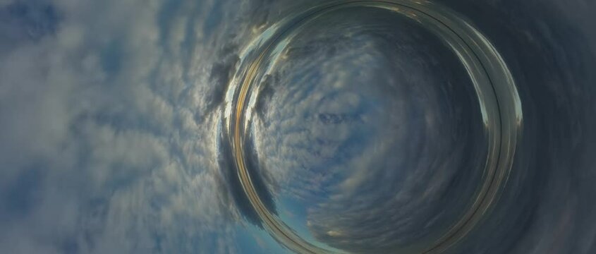 Prepare to embark on an extraordinary visual voyage through the captivating depths of a wormhole. Our mind-bending journey begins with a serene daytime sky, where fluffy white clouds lazily drift