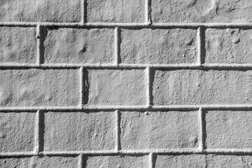 Textured white brick wall with a rough finish illuminated by natural light in a cozy setting