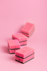 Pink kitchen sponges for washing dishes on a pink background. Homework. Household work. Washing dishes.