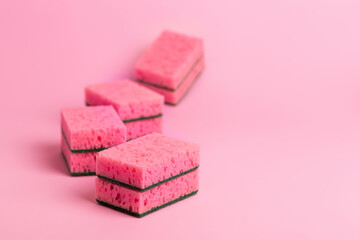 Pink kitchen sponges for washing dishes on a pink background. Homework. Household work. Washing dishes.