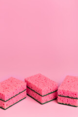Pink kitchen sponges for washing dishes on a pink background. Homework. Household work. Washing dishes.