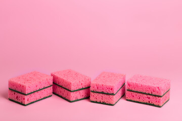 Pink kitchen sponges for washing dishes on a pink background. Homework. Household work. Washing dishes.