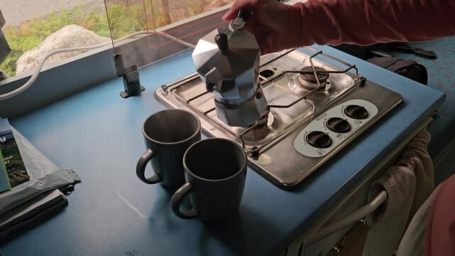 Pouring coffee in the campervan, made with a Neapolitan coffee maker.