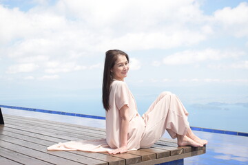 絶景のびわこテラスでウッドデッキに座る笑顔のシニア女性