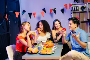 Friends celebrate indoors with food and wine, sharing laughs and toasts at a festive gathering.