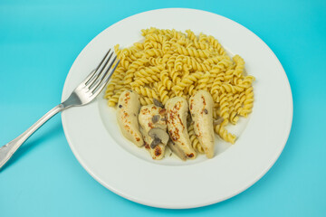 filet de poulet sauce champignons et pâtes, en gros plan, dans une assiette