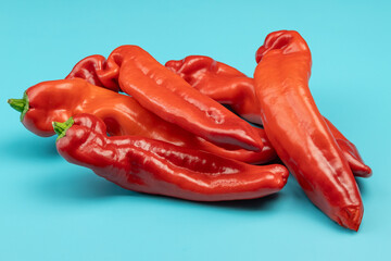tas de poivrons rouges, isolés sur un fond bleu