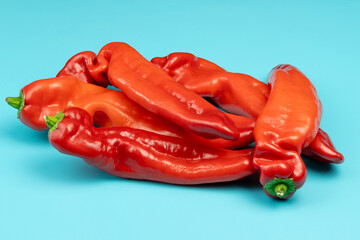 tas de poivrons rouges, isolés sur un fond bleu