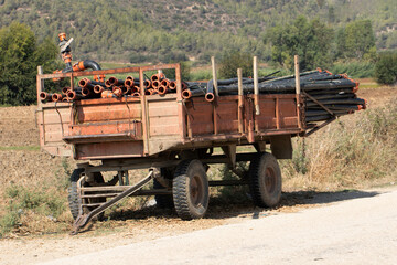 Obraz premium A trailer loaded with sprinkler water pipes parked by the edge of a crop field
