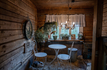 old wooden chairs and a table covered with dust in a wooden interior