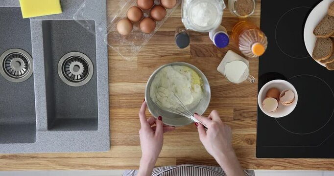 Mixing eggs, milk and pepper for breakfast in kitchen