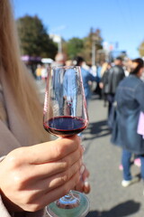 Savoring an exquisite glass of wine while enjoying an outdoor festival with friends and good vibes