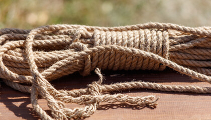 A bunch of brown rope is laying on a wooden surface