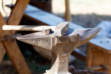 A hammer and an anvil are on a table