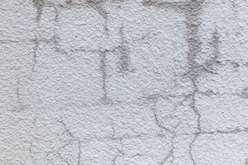A wall with a lot of cracks and holes