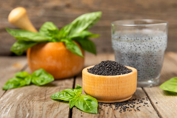 Basil seeds on textured wooden background. Close-up. Superfood. Ocimum basilicum. Organic basil seeds. selasih. Space for text. Copy space.