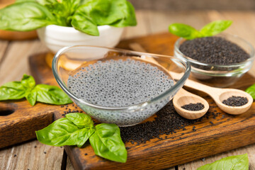 Basil seeds on textured wooden background. Close-up. Superfood. Ocimum basilicum. Organic basil seeds. selasih. Space for text. Copy space.