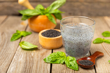 Basil seeds on textured wooden background. Close-up. Superfood. Ocimum basilicum. Organic basil seeds. selasih. Space for text. Copy space.