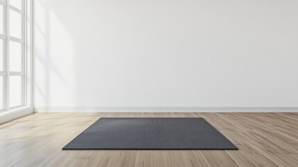 A gray yoga mat is laid out on a light wood floor in a bright room with a large window.