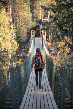 man in a yellow jacket crossing a suspension bridge in Finland