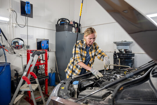 female mechanic working on a car in garage