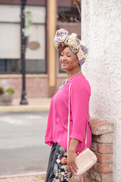 Woman laughing outside wearing bright clothing