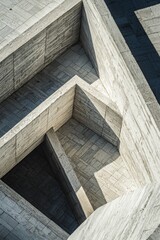 A top-down view of geometric architecture with sharp lines, casting bold shadows in the midday sun.