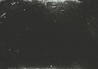 Black grunge background with white stain. Scratched surface backdrop. Abstract weathered wall graphic element. Rough distressed overlay.