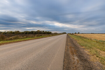 Fototapeta premium A road with a cloudy sky in the background