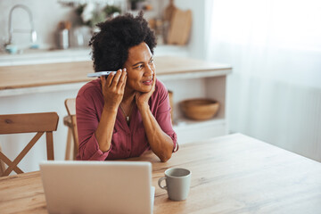 Woman Enjoying a Phone Conversation at Home Desk